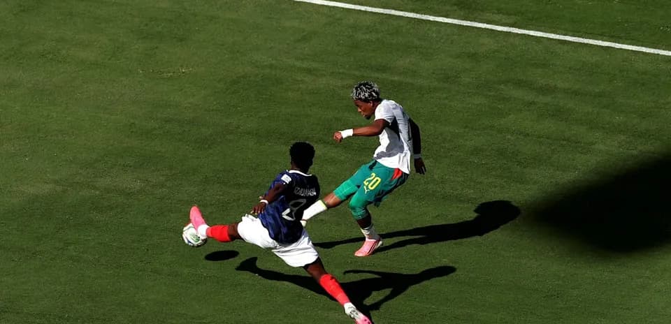 Jugador evadiendo a oponente en el campo de fútbol