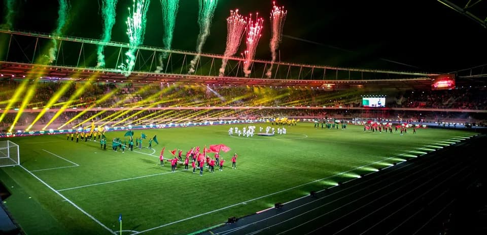 Equipos entrando al campo con fuegos artificiales