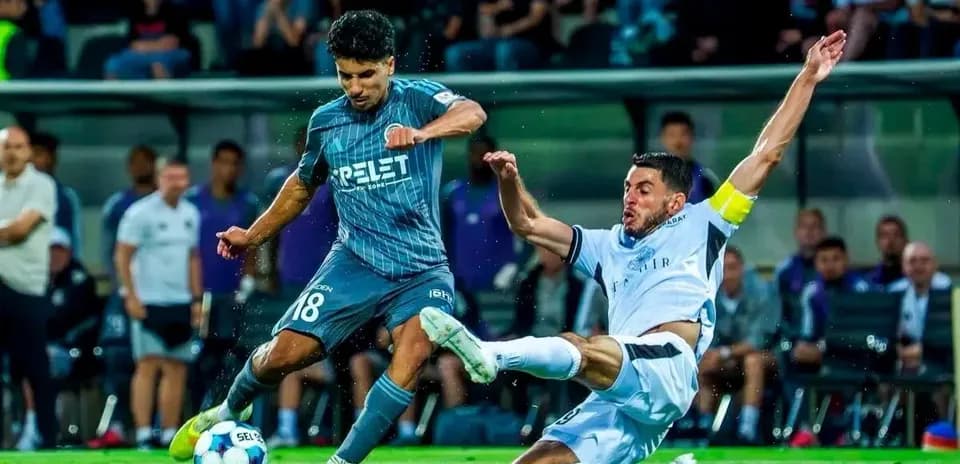 Jugador de Slovan Bratislava deslizándose para recuperar el balón