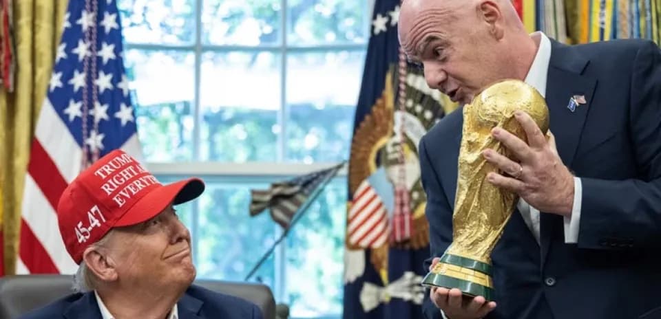 Dos hombres sosteniendo el trofeo de la Copa del Mundo