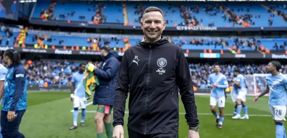 Entrenador sonriendo tras el partido en el estadio