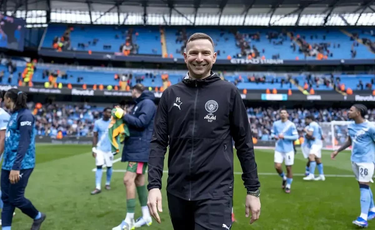 Entrenador sonriendo tras el partido en el estadio