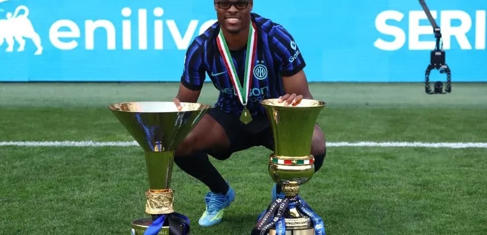 Jugador posando con trofeos en el campo