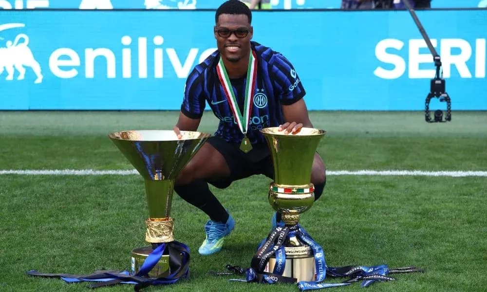 Jugador posando con trofeos en el campo