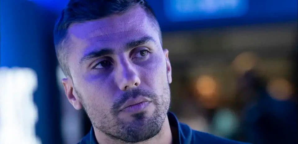 Hombre con camiseta oscura en entorno iluminado