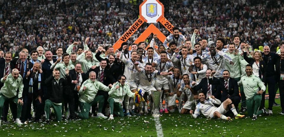 Equipo celebrando victoria con trofeo en el campo