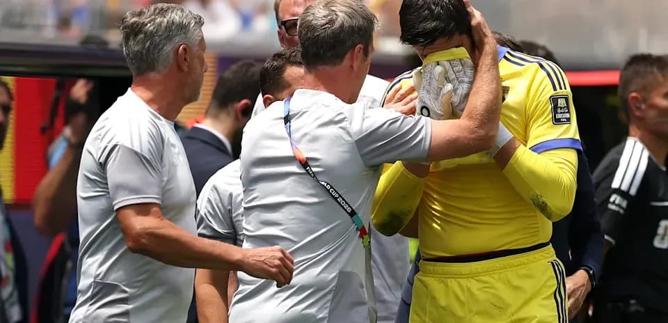 Entrenador consuela al portero en el banquillo
