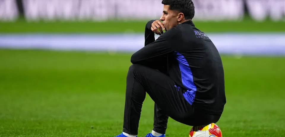 Jugador sentado en el campo con un balón