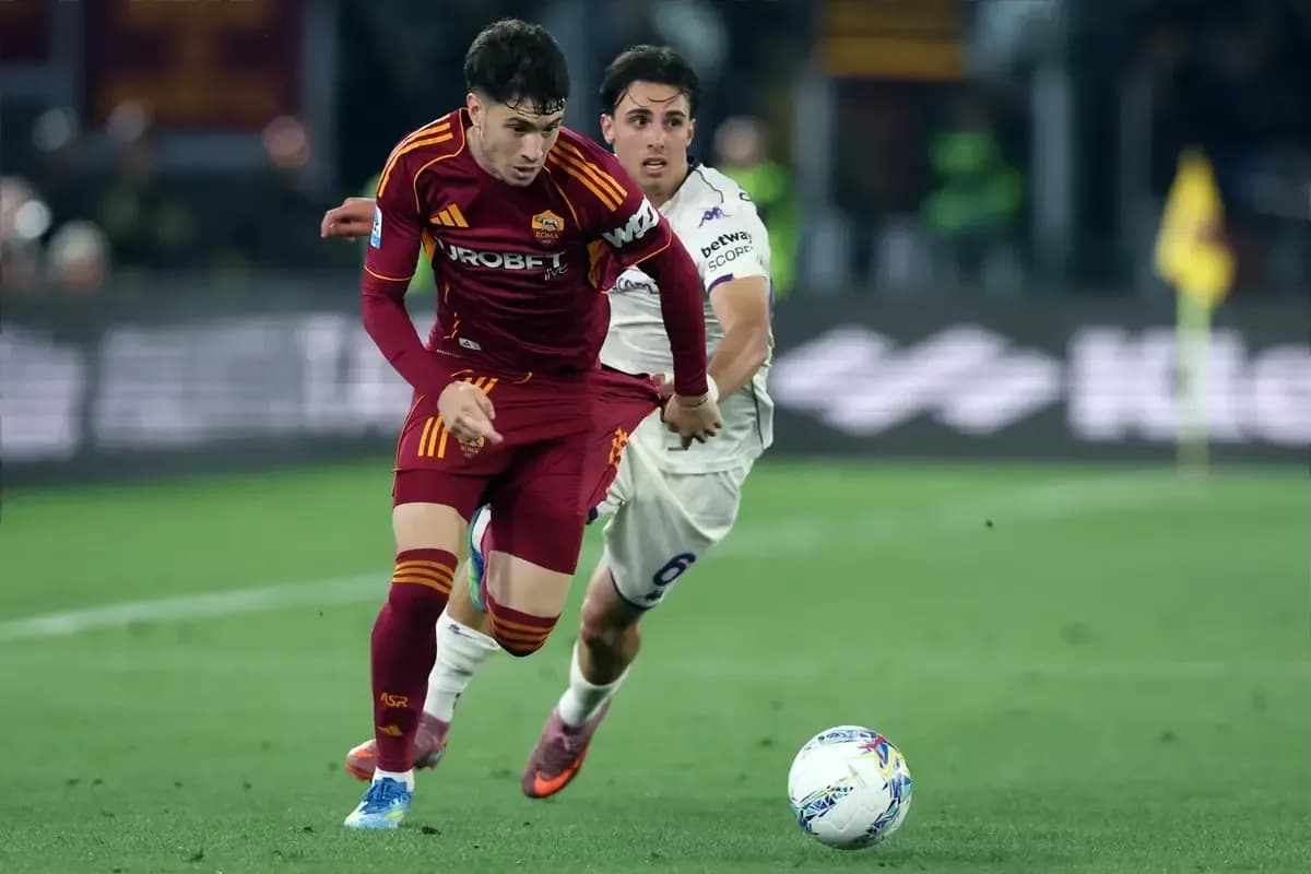 Jugador de Roma driblando mientras es seguido por adversario
