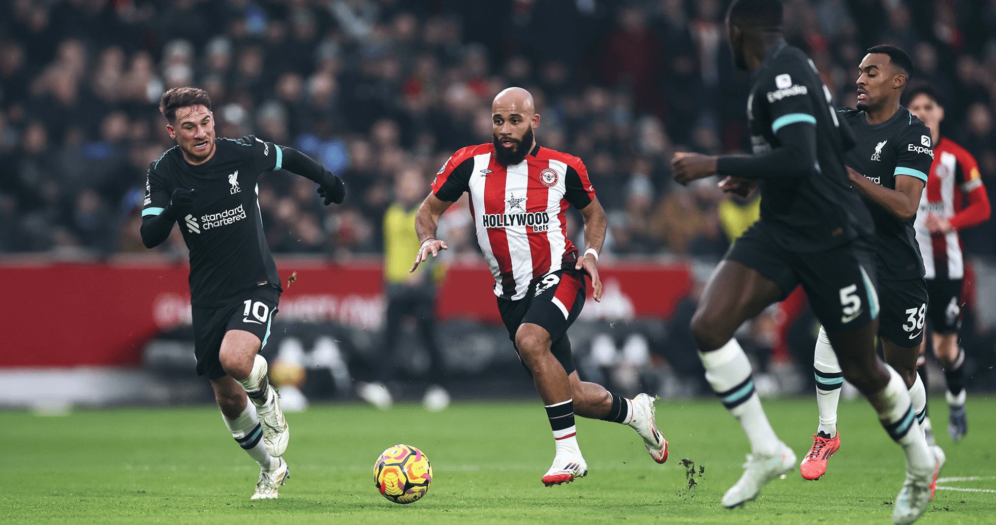 Jugador de Brentford driblando a defensores de Liverpool