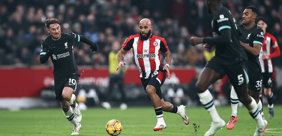 Jugador de Brentford driblando a defensores de Liverpool