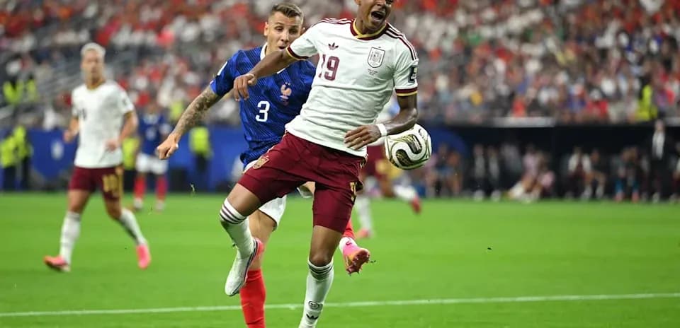 Jugador de España siendo derribado por defensor francés