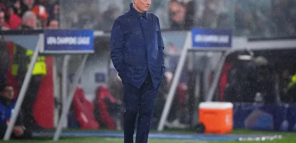 Entrenador en la banda bajo la lluvia durante el partido
