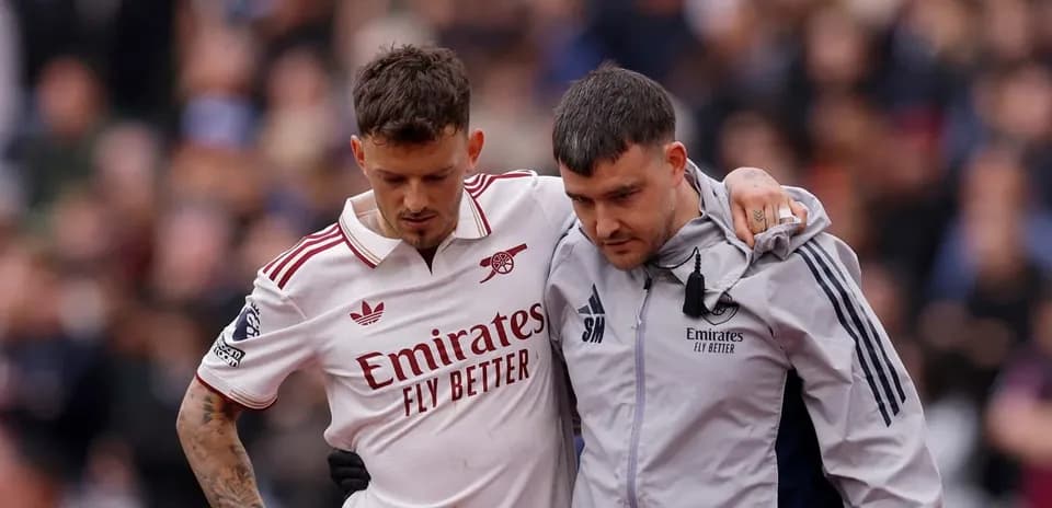 Jugador de Arsenal siendo ayudado por un entrenador