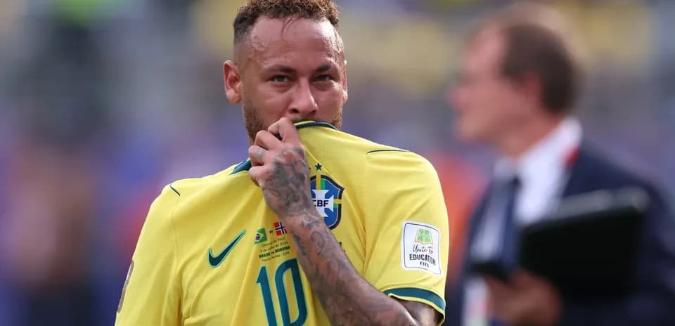 Neymar sosteniendo su camiseta de Brasil en el campo