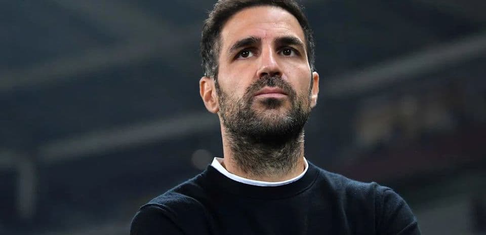 Hombre observando un partido de fútbol desde el banquillo