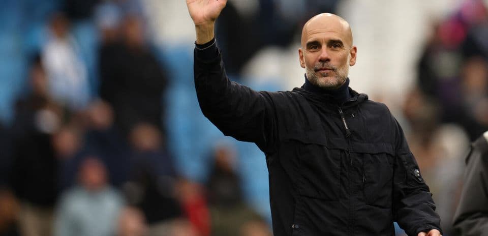 Entrenador saludando desde el borde del campo