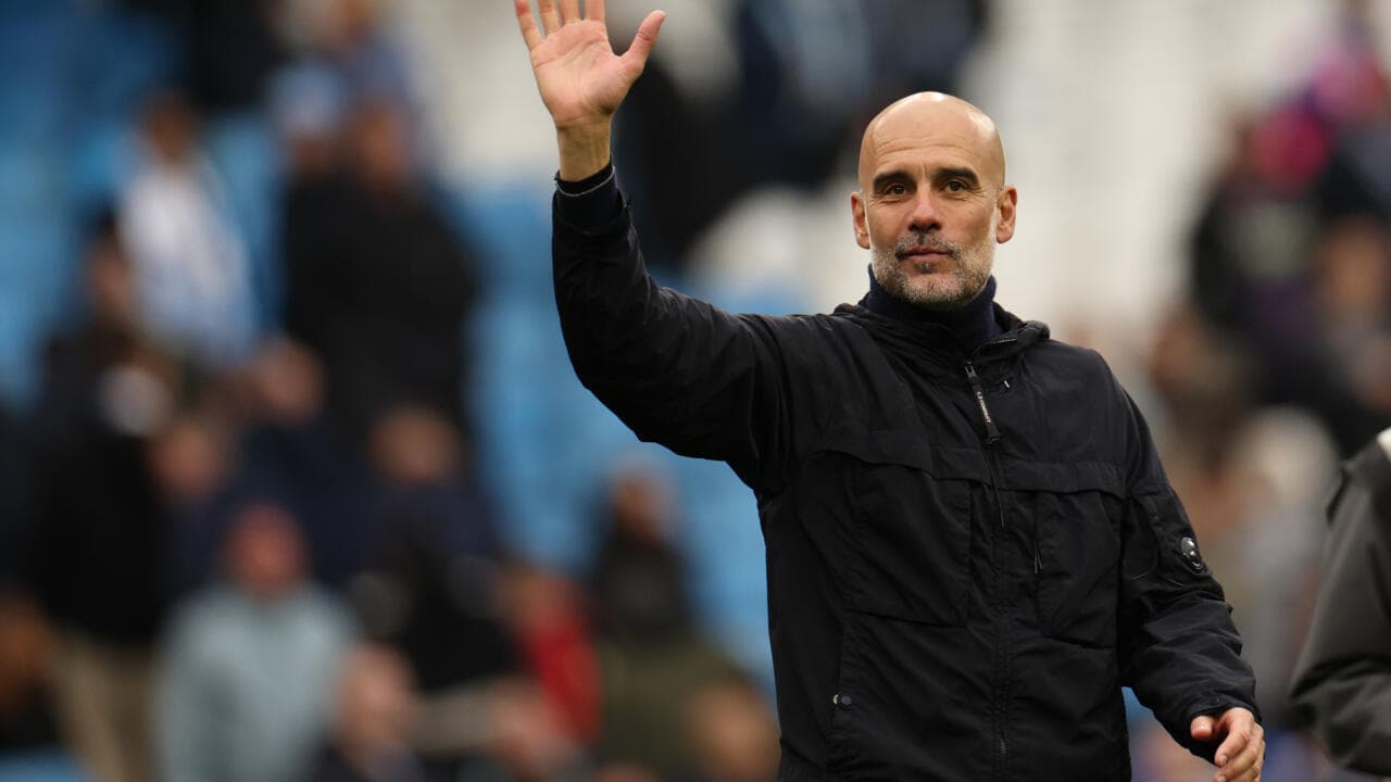 Entrenador saludando desde el borde del campo