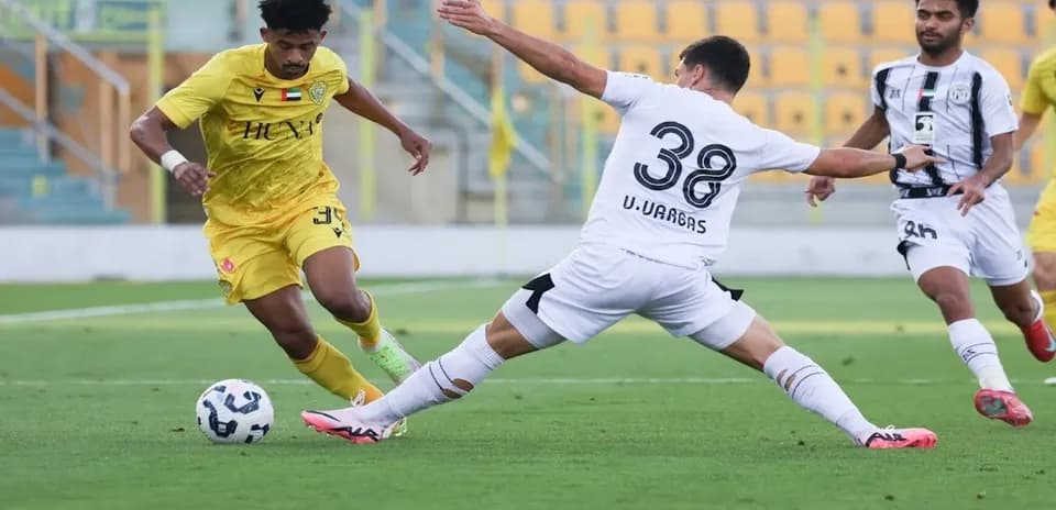 Jugador driblando en partido de fútbol U23