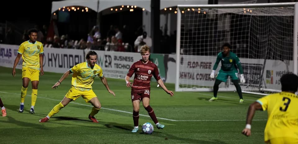 Jugadores compitiendo en partido de fútbol