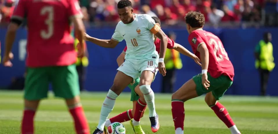 Jugador francés con balón rodeado por defensores marroquíes
