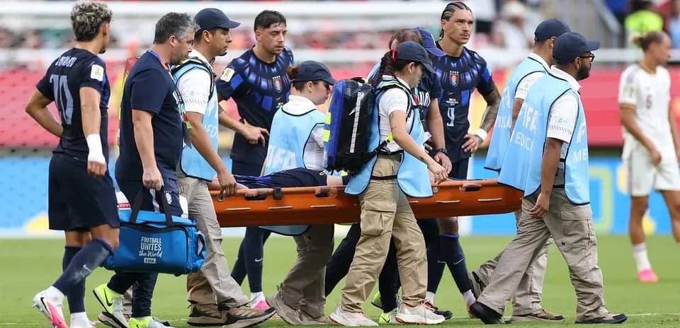 Jugadores y personal médico trasladando a jugador lesionado