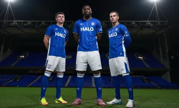 Tres jugadores posando en el campo de fútbol
