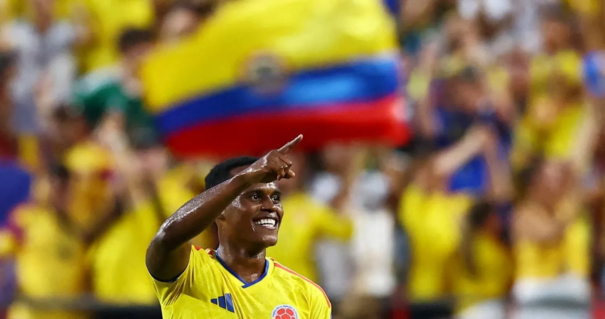 Jugador colombiano celebrando con aficionados en estadio