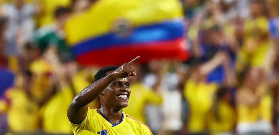 Jugador colombiano celebrando con aficionados en estadio