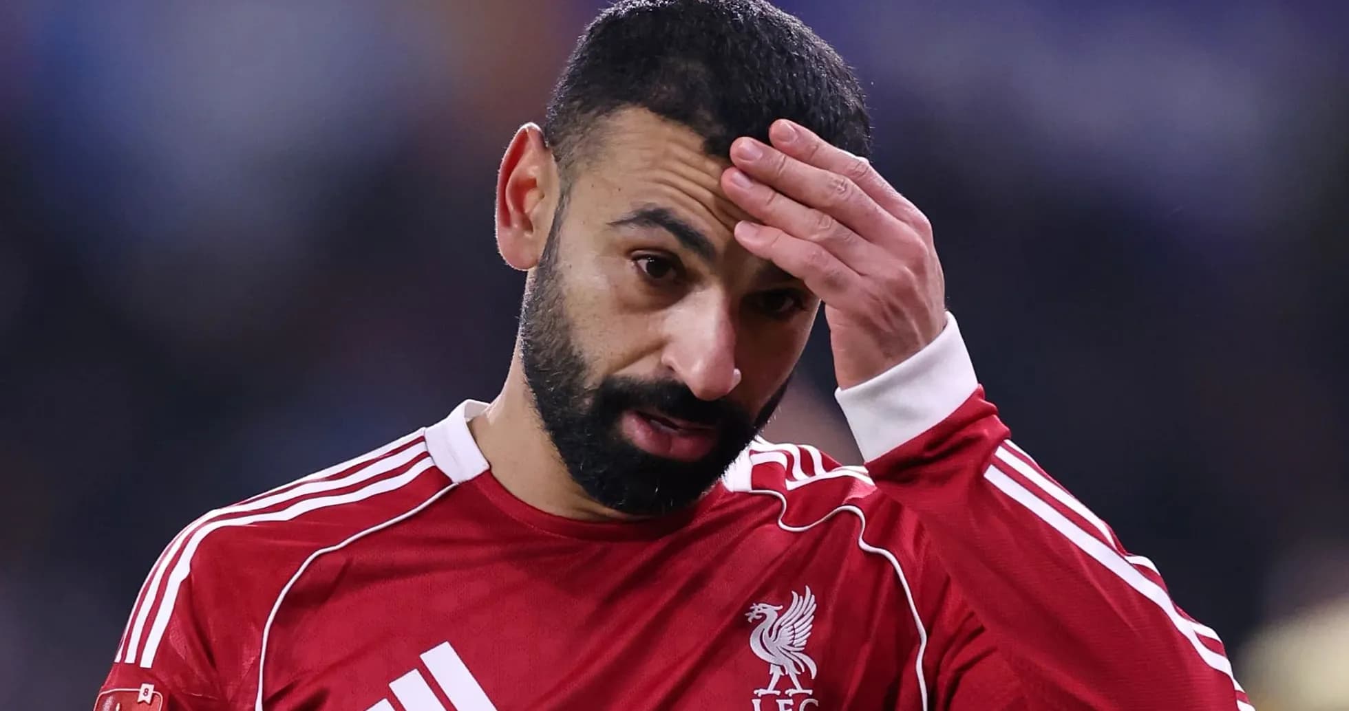 Jugador de Liverpool tocándose la frente durante el partido