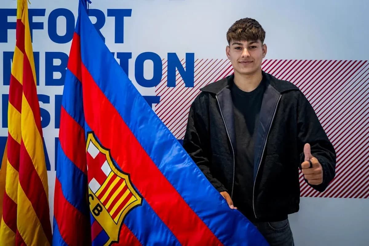 Jugador sosteniendo bandera del FC Barcelona en evento