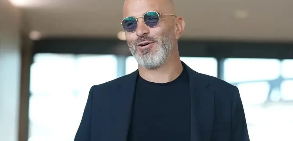 Hombre con barba y gafas de sol en interior