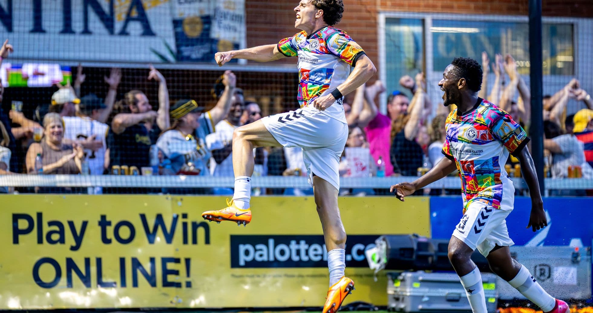 Jugador celebra un gol con aficionados en el fondo