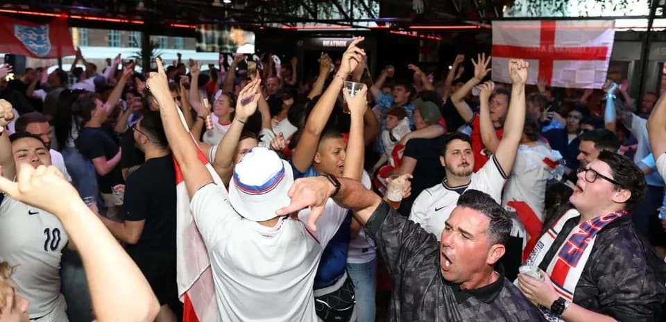 Aficionados de Inglaterra celebrando en un bar