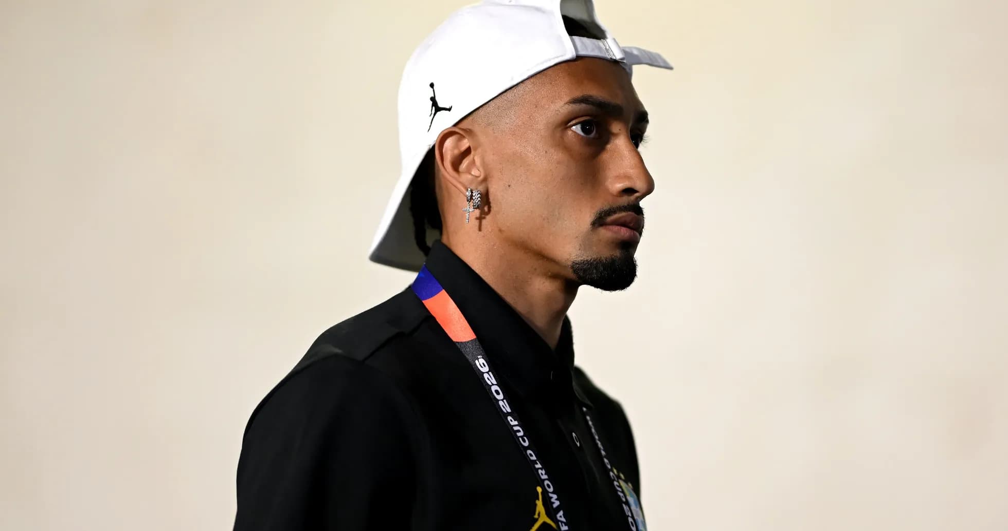 Jugador con gorra y camiseta negra en pasillo