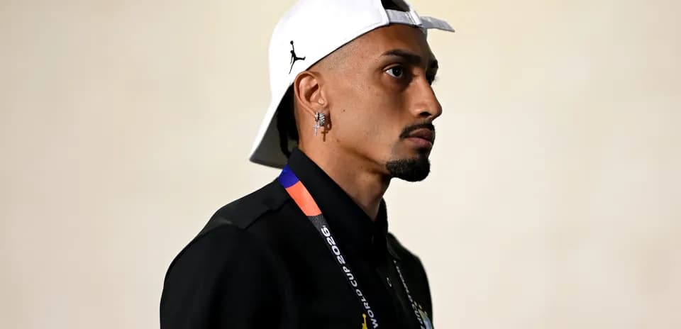 Jugador con gorra y camiseta negra en pasillo