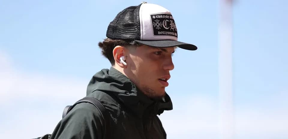 Jugador con gorra y auriculares caminando al estadio