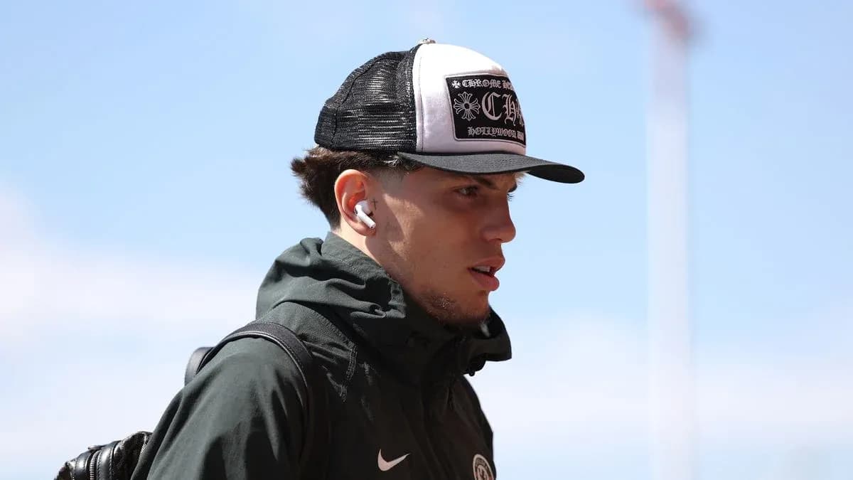 Jugador con gorra y auriculares caminando al estadio
