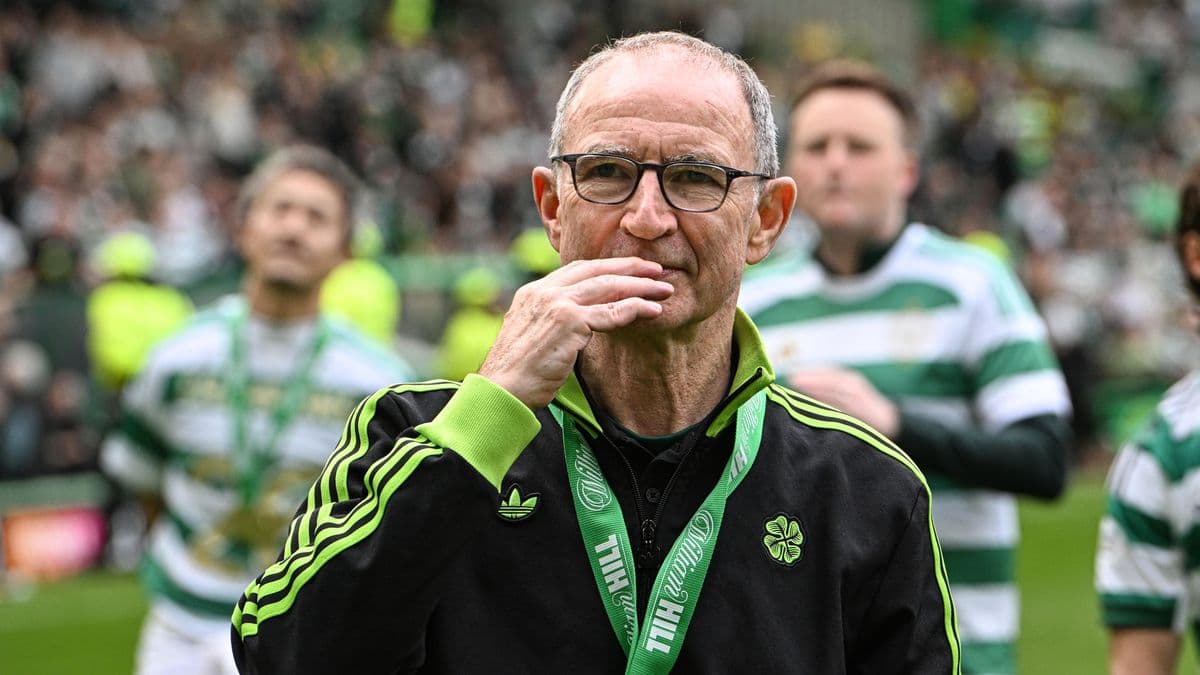 Entrenador de pie en el campo con medalla