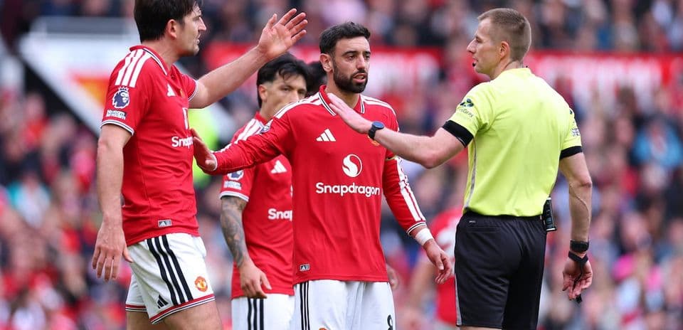 Jugadores de Manchester United discutiendo con el árbitro
