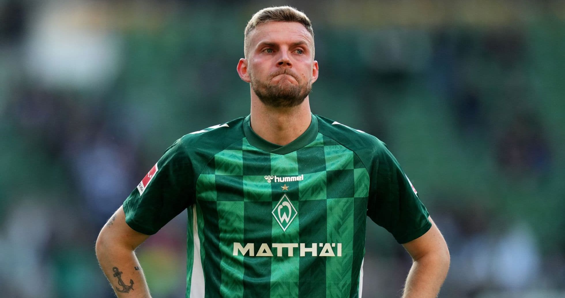 Jugador de Werder Bremen con camiseta verde en el campo