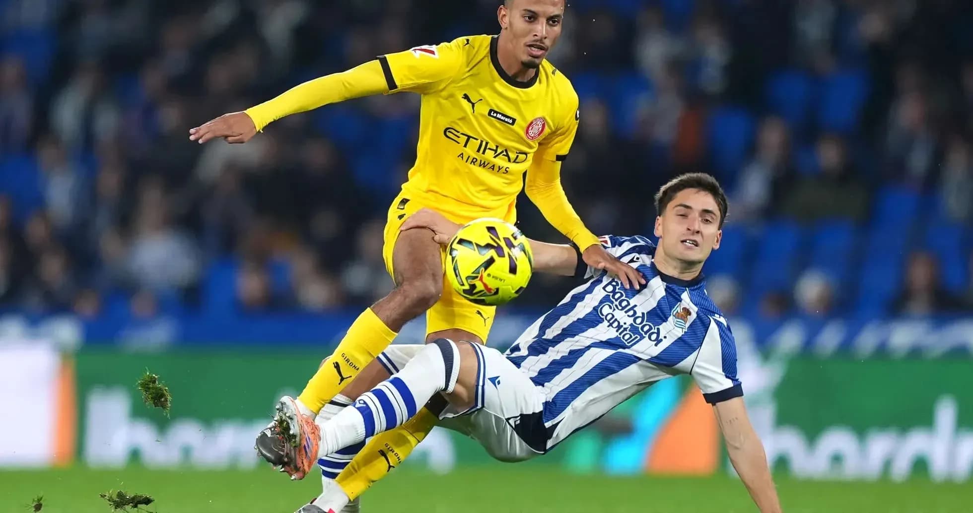 Jugador de Girona driblando a rival de Real Sociedad