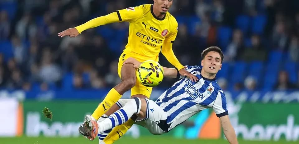 Jugador de Girona driblando a rival de Real Sociedad