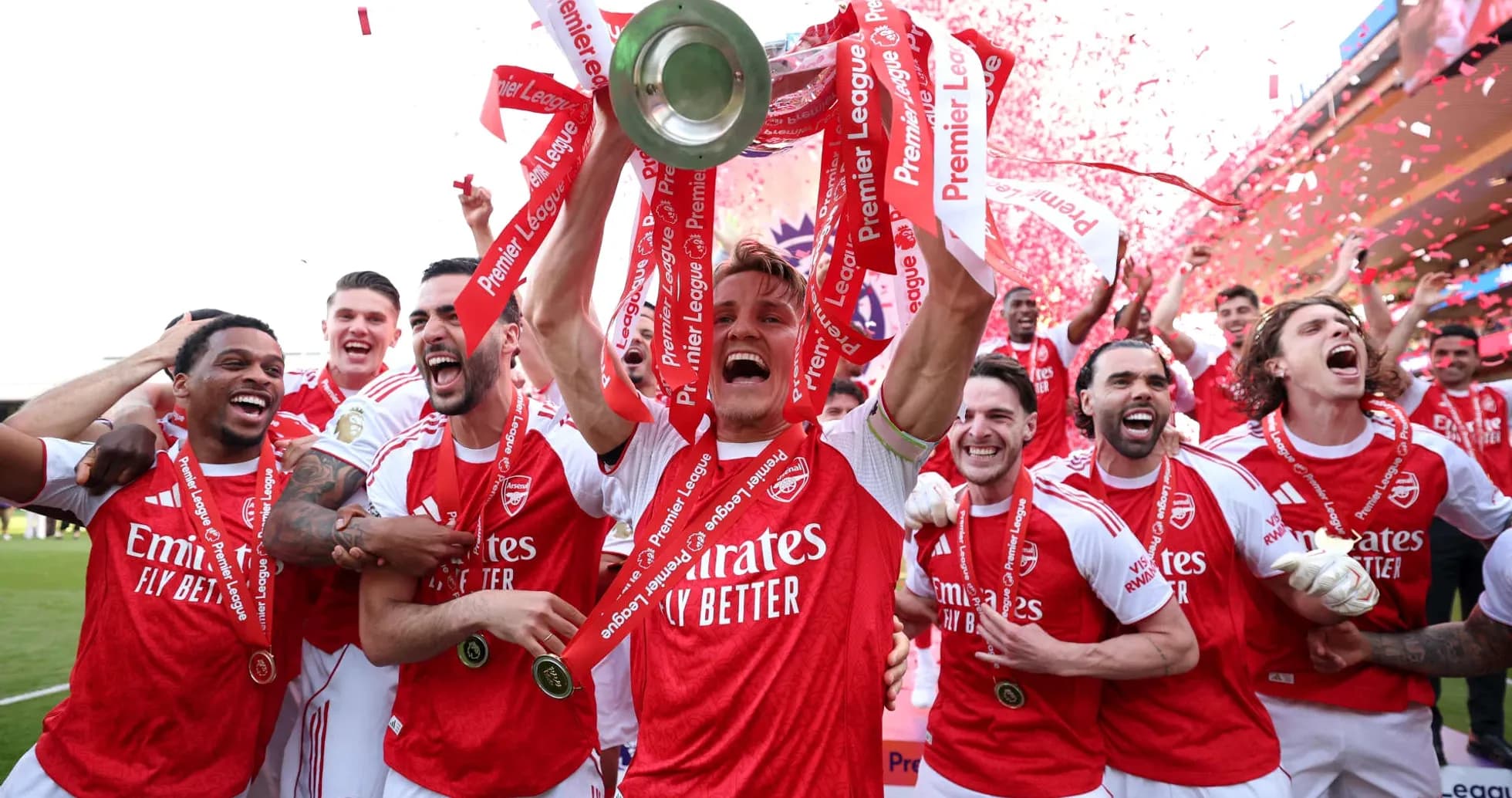 Jugadores de Arsenal celebrando con trofeo y cintas