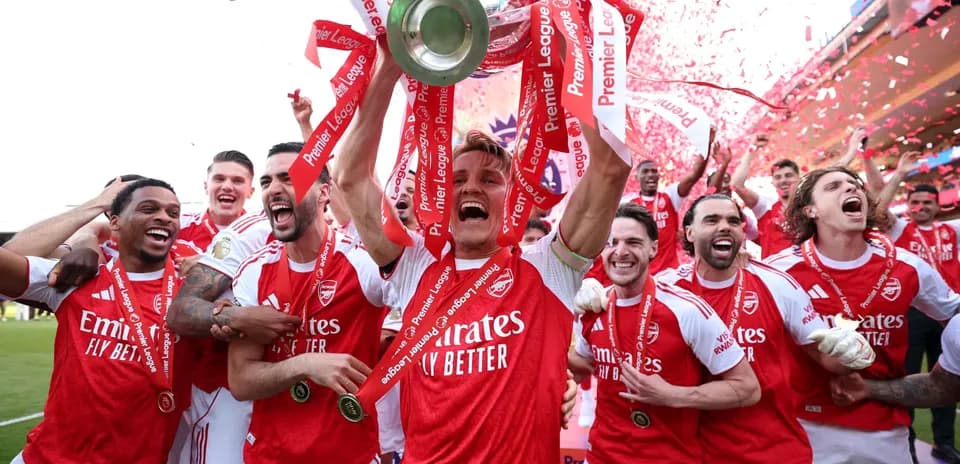 Jugadores de Arsenal celebrando con trofeo y cintas
