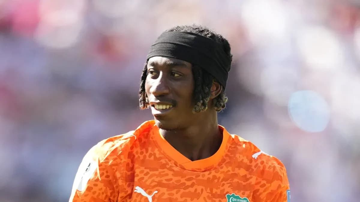 Portero con camiseta naranja sonriendo en el campo