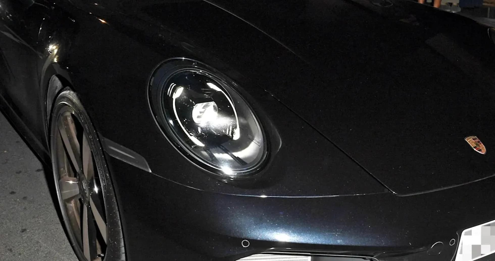 Dos personas dentro de un Porsche negro en la noche