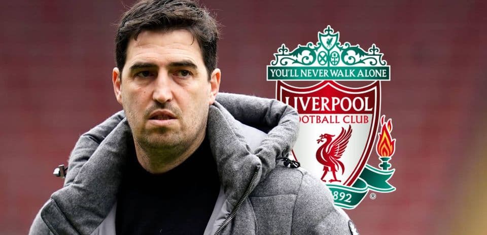 Entrenador junto al escudo del Liverpool FC
