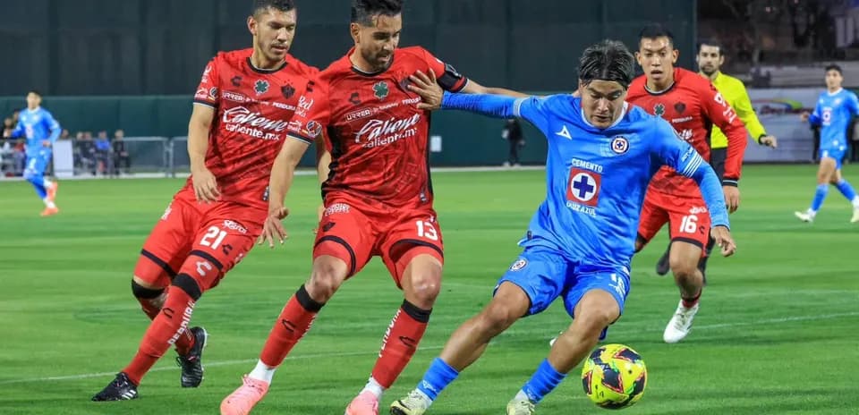Jugador de Cruz Azul desafiando a defensores de Atlas