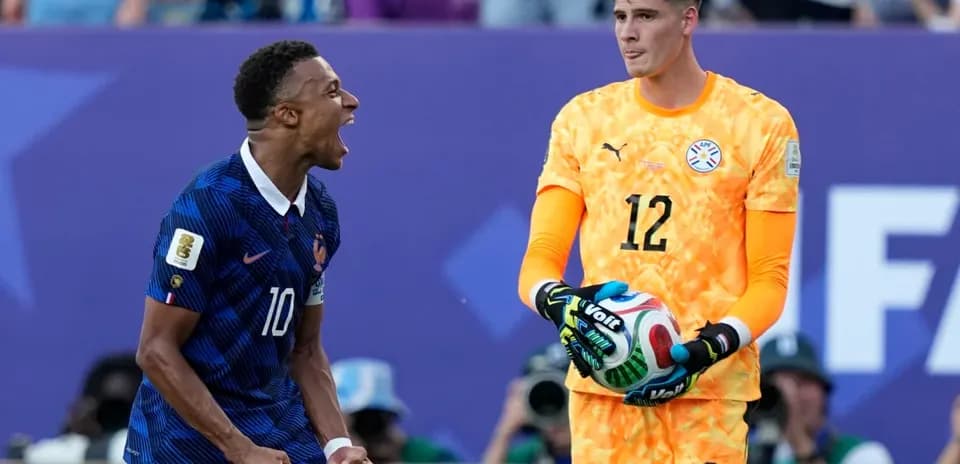 Jugador de Francia celebrando mientras portero de Paraguay sostiene balón